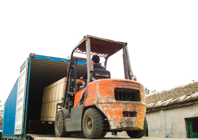 Electric Forklift Loading Cargos into Container